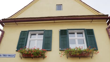 Ventanas-De-Persianas-Verdes-Abiertas-Del-Edificio-Beige-Durante-El-Día