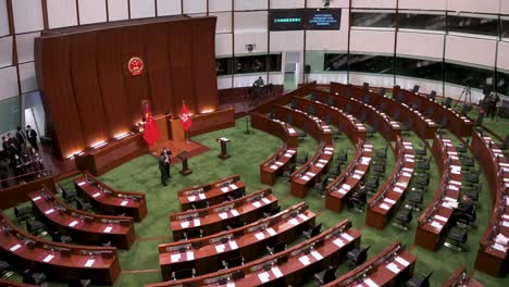 View-of-an-empty-Legislative-Council-main-chamber-as-the-People's-Republic-of-China-emblem-and-Hong-Kong-flags-are-seen-in-front-of-the-presidential-elected-chair