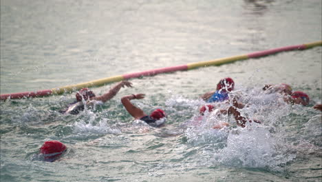 Group-of-latin-teenage-girls-female-contestants-participants-competitors-entering-the-water-to-start-the-triathlon-competition