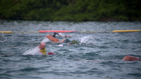 Gruppe-Von-Sportlerinnen,-Die-Müde-Und-Erschöpft-Bei-Einem-Triathlon-Wettkampf-Schwimmen-Und-Mützen-Und-Schutzbrillen-Tragen