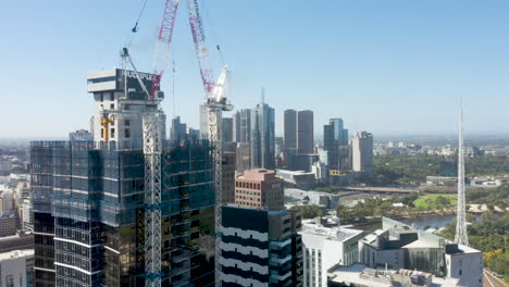 Aerial-ramp-perspective-moving-toward-and-past-crane-on-apartment-construction-site