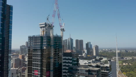 Seguimiento-Panorámico-De-La-Grúa-De-Construcción-De-Un-Nuevo-Edificio-Que-Se-Está-Desarrollando-En-Melbourne,-Australia