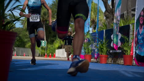 Zeitlupe-Von-Zwei-Jugendlichen-Männlichen-Athleten,-Die-An-Der-Ziellinie-Eines-Triathlon-Wettbewerbs-Gegeneinander-Antreten