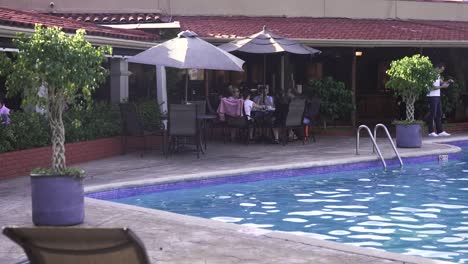 Gente-Disfrutando-De-Un-Brunch-De-Cócteles-En-El-área-De-La-Piscina-Del-Hotel-Double-Tree-Resort,-Tiro-Medio-Ancho