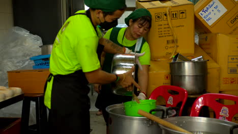 Tailandia,-Bangkok---13-De-Agosto-De-2022:-Filtrado-De-Agua-De-Coco-Con-Un-Colador-En-Una-Olla-En-La-Fabricación-De-Gelatina-De-Coco-Por-Dos-Trabajadoras