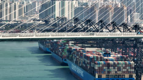 Tres-Barcos-De-Transporte-Cosco-Amarrados-En-Fila-En-La-Terminal-De-Contenedores-Act-Hongkong-Con-Tráfico-En-El-Puente-De-Los-Canteros-Y-El-Distrito-De-Kwai-Ching-En-El-Fondo