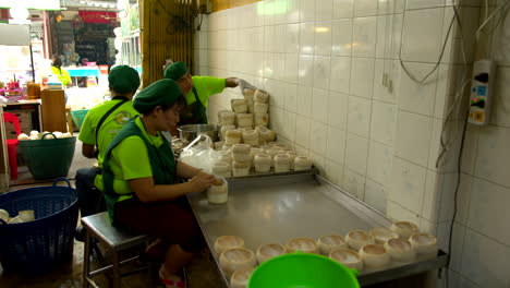 Thailand,-Bangkok---13-August-2022:-Workers-preparing-the-bowl-for-coco-jelly,-cutting-the-top-and-emptying-the-water-and-extracting-the-pulp-using-scraper