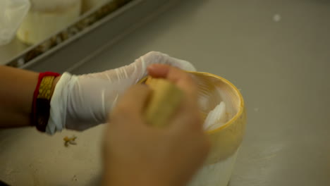 Thailand,-Bangkok---13-August-2022:-Close-up-unrecognizable-worker-extracting-coconut-pulp-from-the-shell-using-scraper