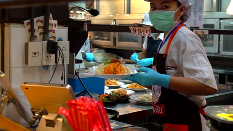 Thailand,-Bangkok---18-August-2022:-Slow-motion-pad-thai-dish-garnished-with-chili-served-by-woman-chef-in-thai-restaurant