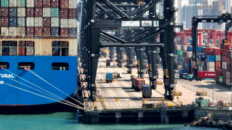 aerial-of-harbour-side-operations-and-stern-view-of-fully-laden-container-ship