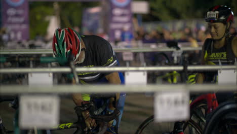 Atleta-Masculino-Senior-Con-Casco-Bombeando-Aire-En-La-Rueda-De-Su-Bicicleta-Temprano-En-La-Mañana-Antes-De-Que-Comience-La-Competencia