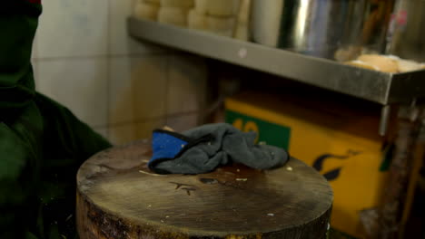 Thailand,-Bangkok---13-August-2022:-Unrecognizable-man-cutting-green-peeled-coconut-with-cleaver-to-be-used-as-edible-bowl-for-coconut-jelly