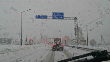 POV-of-waiting-for-red-light-in-a-car-in-snowfall-weather-while-winter