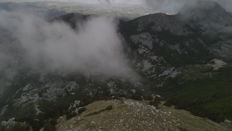 Vista-Aérea-Hacia-El-Enorme-Acantilado-Con-Algo-De-Niebla-En-Medio-De-La-Montaña-Lovcen-En-Montenegro