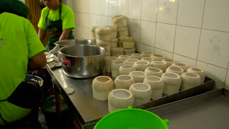 Thailand,-Bangkok---13-August-2022:-Workers-in-industry-backroom-preparing-the-shell-for-coco-jelly-cutting-fresh-peeled-green-coconut