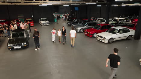 Luftaufnahme-Nach-Bmw-E30-Club-Fan,-Der-Klassische-Fahrzeuge-Bewundert,-Die-Im-Warehouse-Car-Show-Meeting-Geparkt-Sind