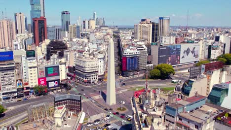 Aerial-view-establishing-the-obelisk-and-downtown-Buenos-Aires,-with-advertisements-on-the-sides-and-representative-buildings-of-the-city