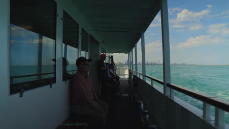 Men-sitting-along-side-of-boat-taking-them-into-the-ocean-with-beautiful-Chicago-skyline-behind-them