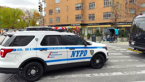 Gran-Furgoneta-Negra-De-Seguridad-Pasando-Seguida-Por-Un-Coche-De-Policía-De-La-Policía-De-Nueva-York-En-La-Ciudad-De-Nueva-York