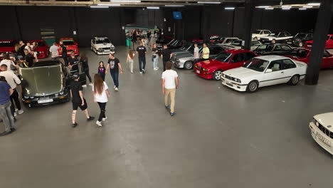 Fans,-Die-Um-Den-Bmw-E30-Car-Club-Herumlaufen,-Treffen-Sich-Mit-Bewundernden-Fahrzeugen,-Luftbild-Folgend