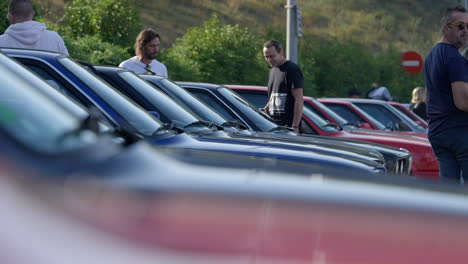 BMW-e30-owners-and-fans-admiring-classic-car-collection-at-Barcelona-exhibition,-Slow-motion