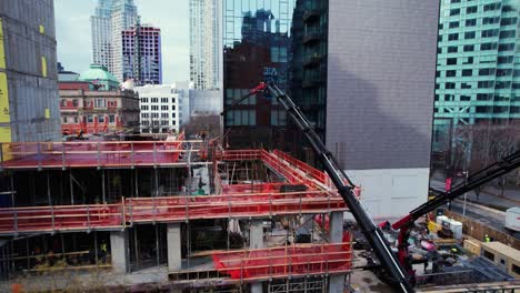 Vista-Aérea-Alrededor-De-Grúas-De-Pluma-De-Nudillo-Rojo-En-Un-Sitio-De-Construcción-En-Jackson-Ave