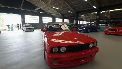 Indoor-aerial-establisher-of-orange-BMW-e30-vintage-car-exposed-at-fan-gathering