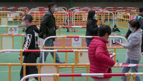 Residents-walk-through-a-queue-line-to-be-tested-for-Covid-19-coronavirus-outside-a-building-placed-under-lockdown-after-a-large-number-of-residents-tested-positive-in-Hong-Kong