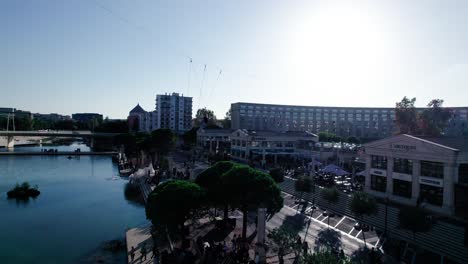 Aerial-shot-of-acrobats-walking-down-a-line-in-the-sky-in-Antigone,-Montpellier,-France