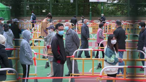 Bürger-Stehen-Auf-Einem-Spielplatz-An,-Um-Vor-Einem-Gebäude,-Das-Unter-Sperrung-Gestellt-Wurde,-Auf-Covid-19-coronavirus-Getestet-Zu-Werden,-Nachdem-Eine-Große-Anzahl-Von-Bewohnern-In-Hongkong-Positiv-Getestet-Wurde