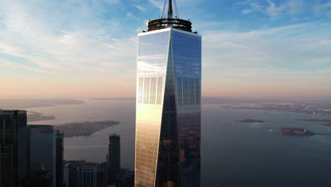 Vista-Aérea-Lejos-De-La-Torre-Wtc-Con-La-Parte-Superior-De-La-Bahía-En-El-Fondo,-En-Nueva-York---Tire-Hacia-Atrás,-Tiro-De-Drones