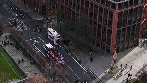 Looking-down-towards-a-TOOTBus-stopping-at-some-lights-below-St-Paul's-Cathedral,-London,-United-Kingdom