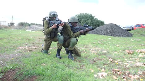 Soldados-Del-Ejército-Israelí-De-Las-Fdi-Entrenando-Caminando-En-Pareja-En-El-Campo-De-Entrenamiento,-Caminando-Apuntando-Rifles-Y-Tomando-Posición-De-Rodillas