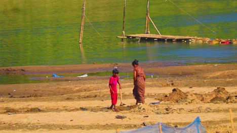 Madre-E-Hijo-Trabajando-En-La-Orilla-Del-Río-Surma-Para-Suelo-Agrícola