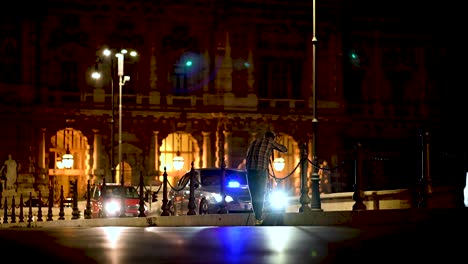 Fotógrafo-Callejero-Tomando-Fotografías-Por-La-Noche-Con-Destellos-De-Luz-Del-Tráfico-Que-Pasa-En-Roma,-Italia