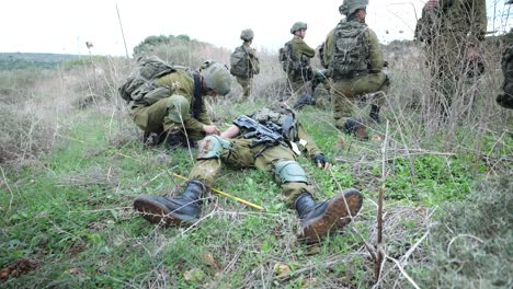 Soldado-De-Infantería-Da-Primeros-Auxilios-A-Un-Colega-Herido-En-Zona-De-Guerra,-Muévete