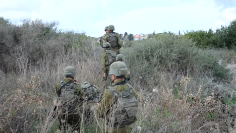 Soldados-De-Infantería-De-La-Brigada-Golani-De-Las-FDI-Moviéndose-En-Terrenos-Arbustivos,-Altos-Del-Golán,-Siria