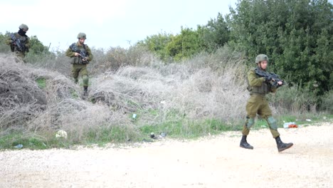 Escuadrón-De-Infantería-De-Israel-Totalmente-Equipado-Con-Rifles-Moviéndose-En-Zona-Rural-Uno-Por-Uno