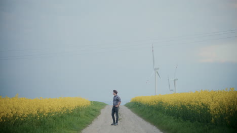 Agricultor-En-La-Carretera-Entre-Plantas-Con-Flores-Contra-El-Cielo