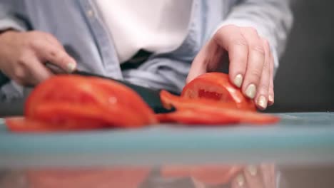 Vorderansicht-Der-Hände-Einer-Frau,-Die-In-Zeitlupe-Frische-Rote-Tomaten-Auf-Einem-Schneidebrett-In-Scheiben-Schneidet.-Nahaufnahme-Der-Hände-Einer-Frau-Mit-Beigem