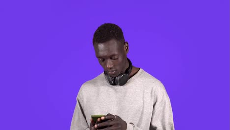 Un-Hombre-Negro-Emocionado-Gana-Sosteniendo-Un-Teléfono-Inteligente-Y-Leyendo-Buenas-Noticias-En-Internet,-Sorprendido-Por-La-Victoria-En-Un-Juego-De-Apuestas-En-Línea-Con-Un-Dispositivo-Móvil,-Un-Hombre-Africano-Feliz