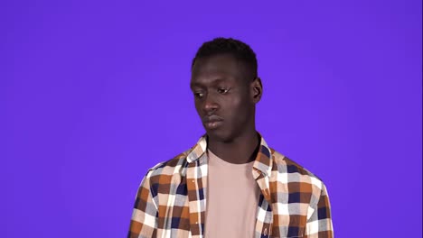 Portrait-young-man-has-and-idea,-pointing-with-finger-up-looking-up,-isolated-blue-wall-background.-Excited-man-with-problem