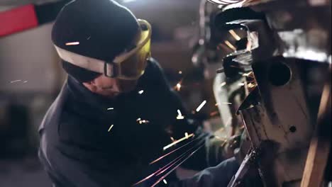 Workman-with-protective-eyewear-is-grinding-metal-construction-with-circular-saw