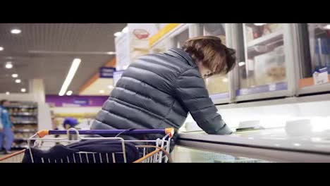 Young-woman-shopping-in-grocery-taking-a-product-from-the-fridge