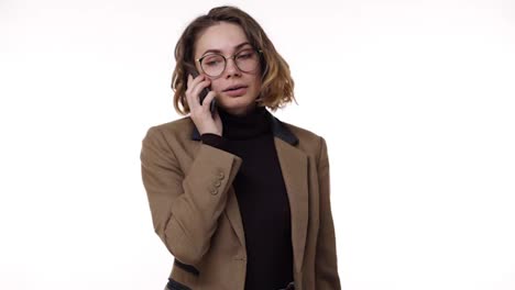 Serious-stylish-young-woman-receiving-good-news-while-talking-on-mobile-phone-isolated-over-white-background-and-got-excited