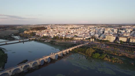 Famous-landmark-bridge-Puente-de-Palmas-in-Badajoz,-Spain,-aerial-orbit-skyline