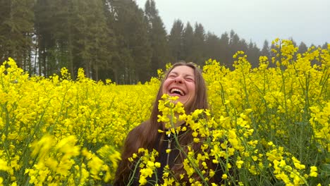 Girl-laugh-inside-yellow-rapeseed-field-walks-towards-camera