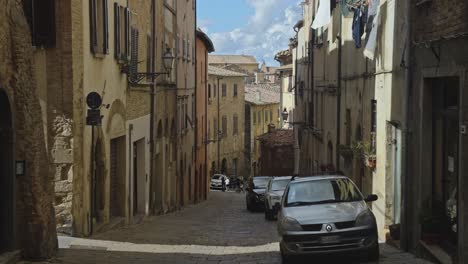 A-pan-across-the-the-quiet-streets-of-the-old-walled-town-of-Volterra,-Province-of-Perugia,-Italy