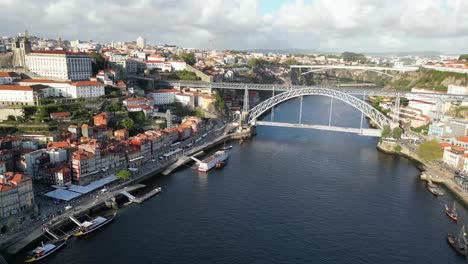 Drone-shot-flying-upwards-with-bridge-in-view-in-Porto-Portugal-at-sunset