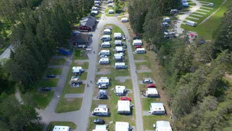 Aerial-overview-of-luxury-campers-in-between-pine-tree-forest-of-Isaberg-resort,-Sweden
